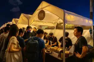How to Make Friends While Traveling: 9 Easy Ways to Connect in 2026 4 “Group of travelers eating together at a food stall”