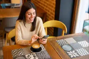 How to Make Friends While Traveling: 9 Easy Ways to Connect in 2026 6 “Solo traveler browsing a social travel app”